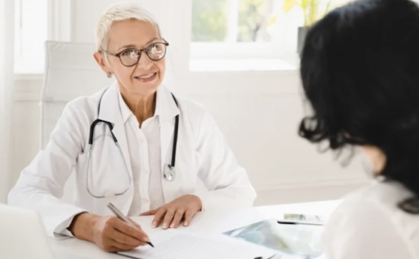 Un médecin femme sourit à une patiente lors d'un rendez-vous